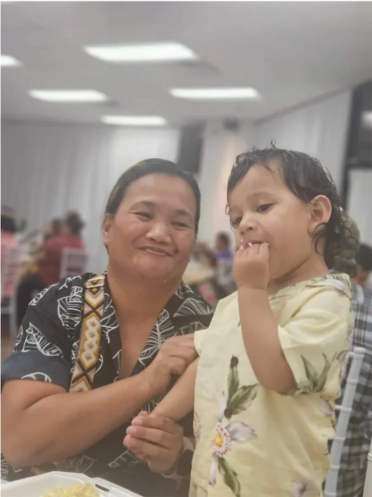 Marshallese women with a child eating food.