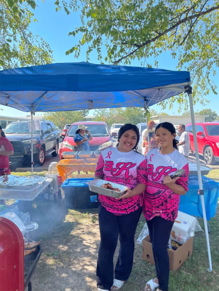 Two women smiling while holding food.